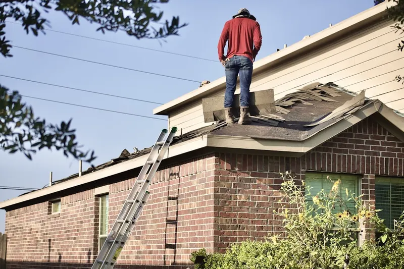 Professional roofer working on a residential roof in Penney Farms